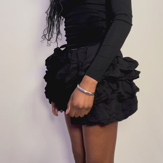 black mini ruffle skirt flattering and playful. Can be worn casually as street style and then elevated to an evening look.